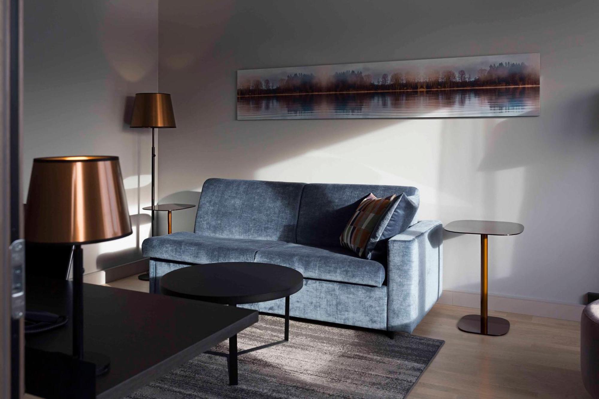 Hilton Helsinki Strand Exterior foto A living room with a blue sofa